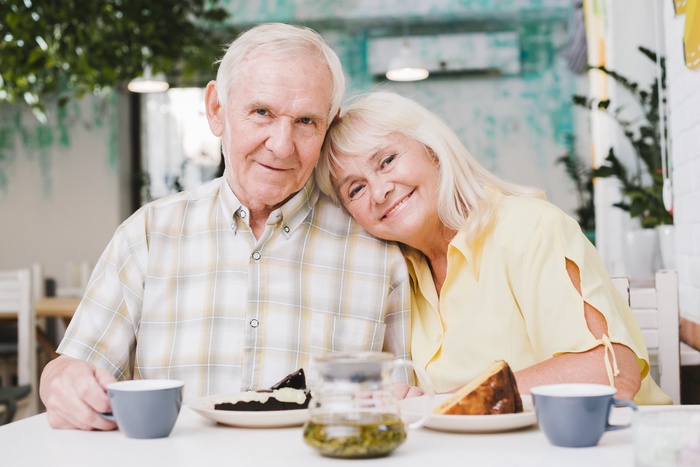  Loving elderly couple drinking tea and eating cake