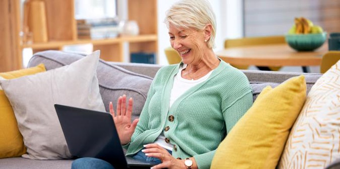 Senior woman smiling using laptop for online dating