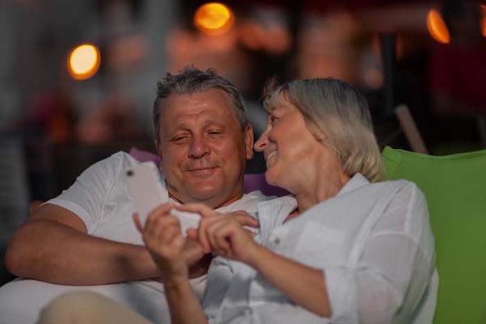 Happy senior couple smiling together while viewing a smartphone