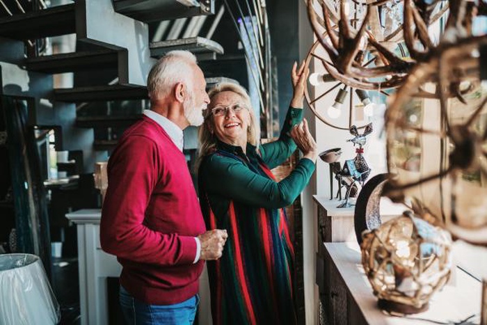 Senior couple in home lighting store shoosing shandelier for their home