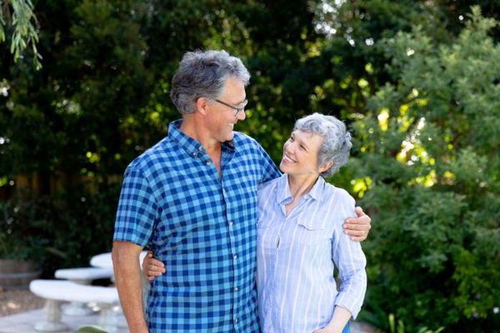A senior couple smiling at each other in the park