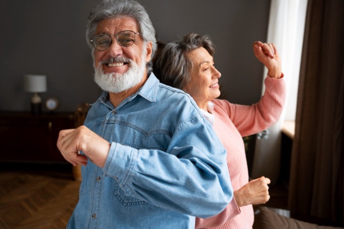 Side view smiley couple dancing indoors