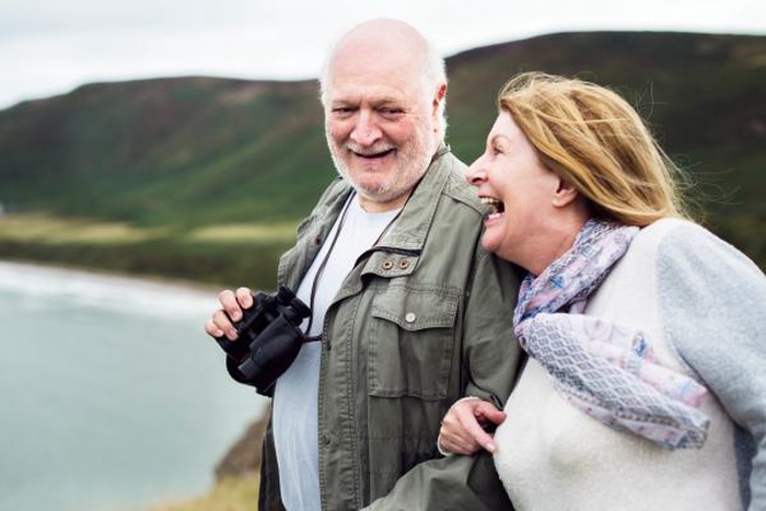 Laughing senior couple enjoying coastal outdoor travel together
