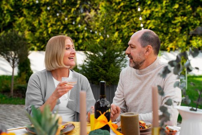 Happy senior couple enjoying outdoor dinner and joyful conversation