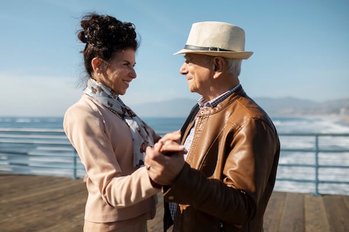 Side view of senior couple dancing on the peer while on a date