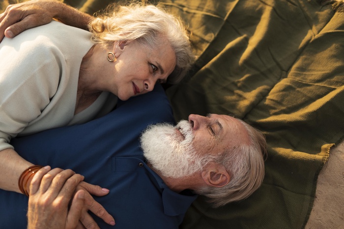 medium shot couple laying oncloth