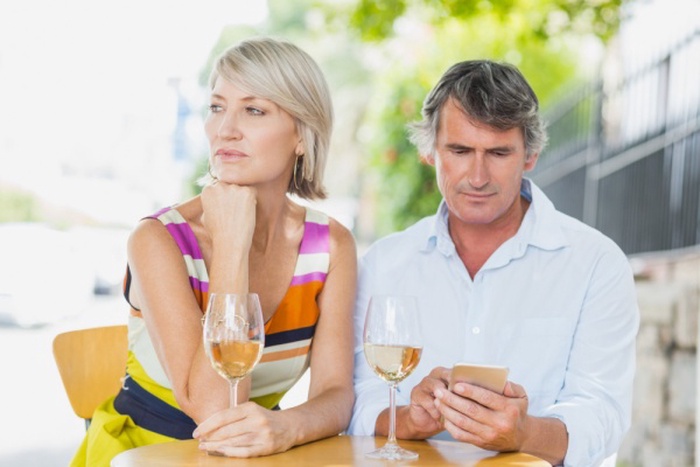 Man using mobile with woman at cafe