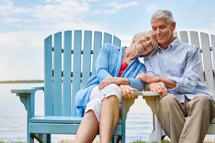 Loving elderly couple resting by the lake