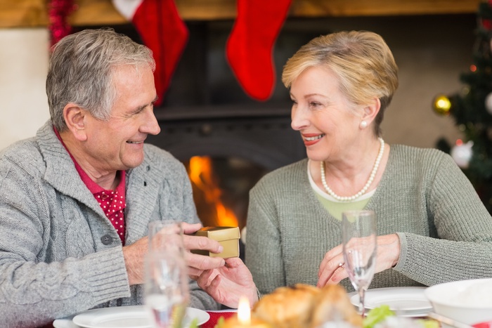 Senior man giving a christmas present to his wife