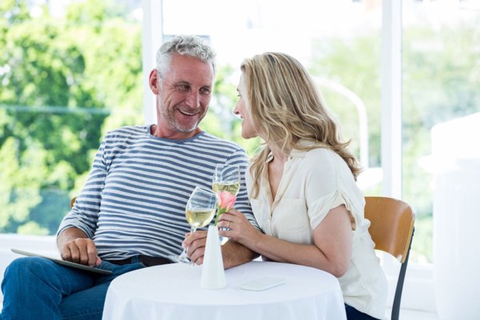 Smiling mature couple having wine