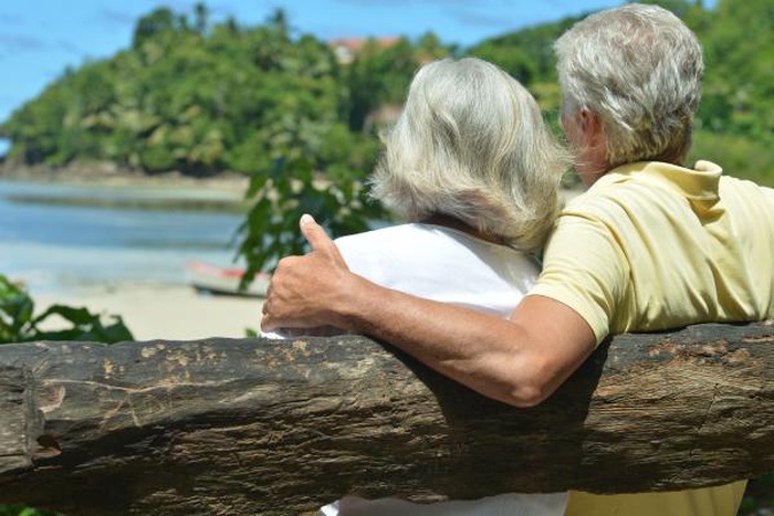 senior couple hugging on wooden bench