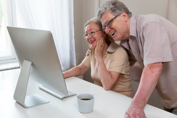 Beautiful grandparents couple learning to use digital device