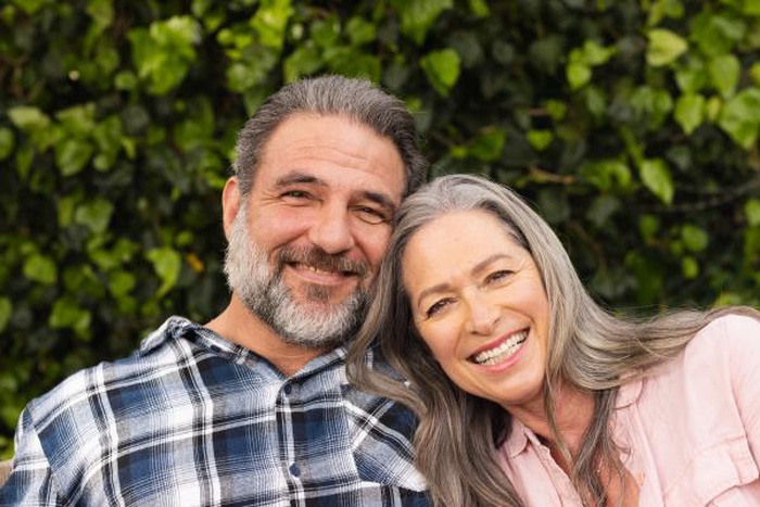 Smiling mature couple enjoying time together outdoors in lush green garden