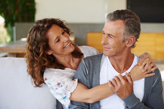 Affectionate mature couple embracing and smiling together indoors