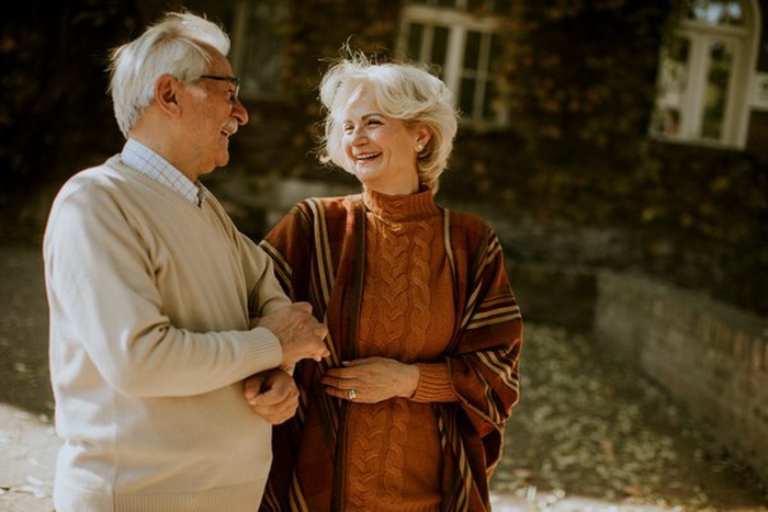 Handsome senior couple walking in autumn park