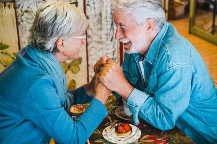 Smiling attractive old senior couple hands in hands