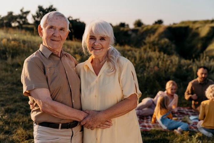 Senior couple holding hands outdoors in meadow