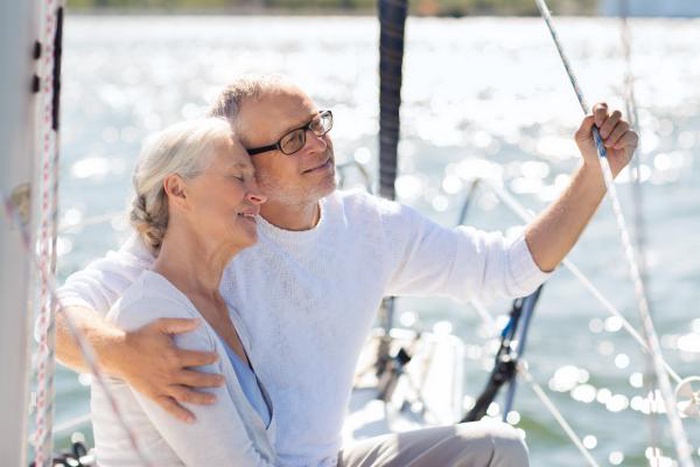 happy senior couple hugging on  sail boat