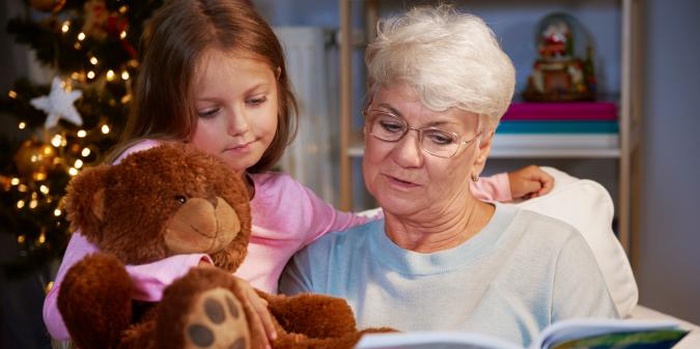 Senior grandmother reading with granddaughter