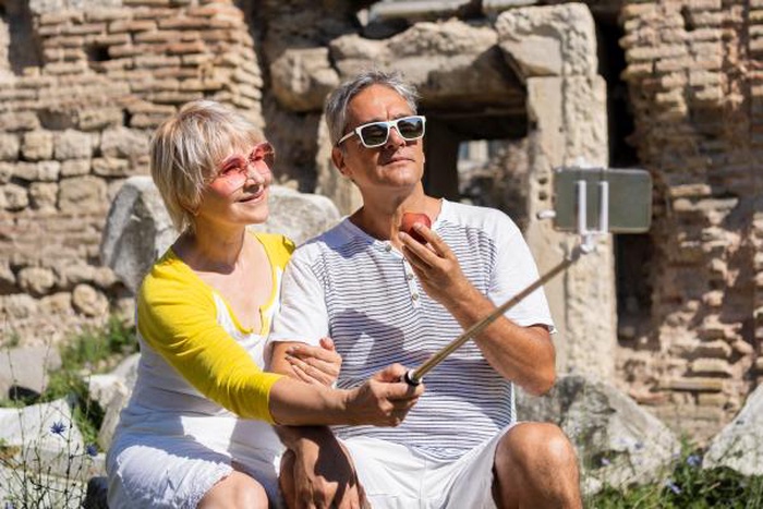 Senior couple taking travel selfie at ancient ruins