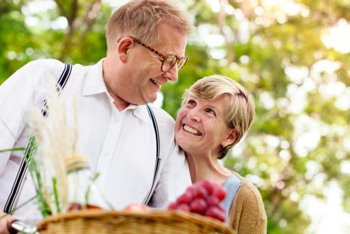 Happy mature couple enjoying outdoor picnic together