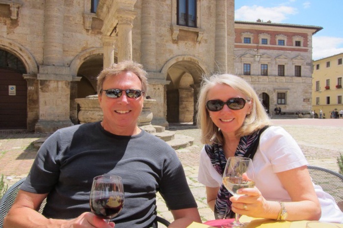 Portrait of smiling mature man and woman sitting against historical buildings