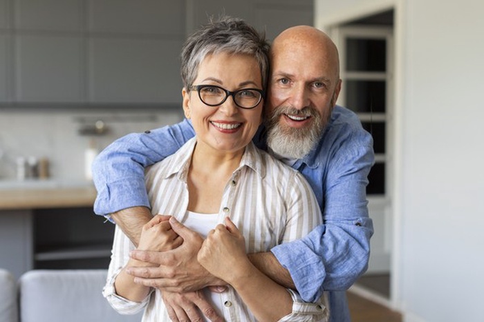loving senior spouses embracing at home