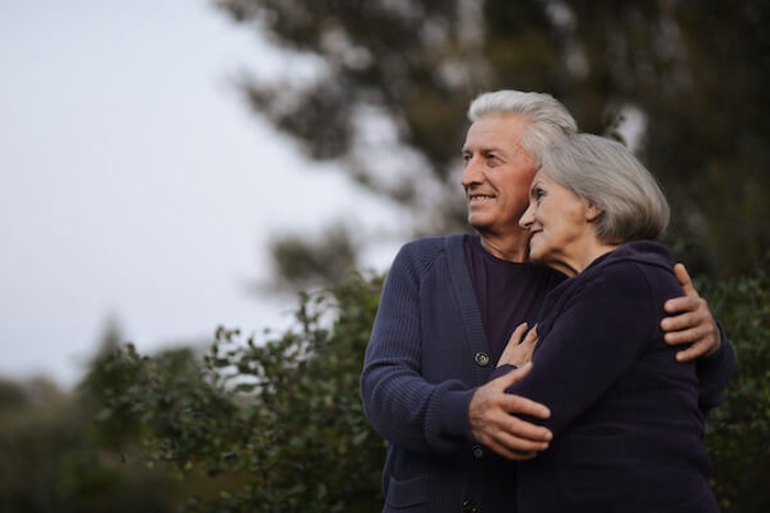 Happy senior couple dancing in the park in summer day