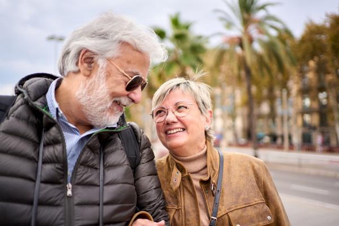 Loving elderly couple strolling in city street