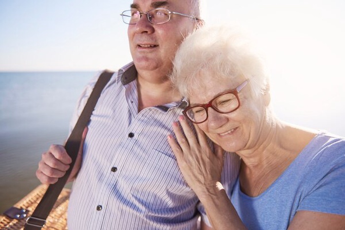 Seniors hugging while going on picnic in the beach