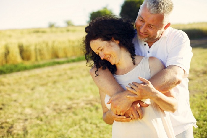 Beautiful adult couple spend time in a summer field
