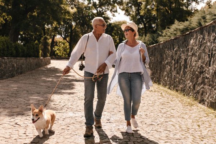 A smiling senior couple walking hand in hand through a sunny park in Banning, California