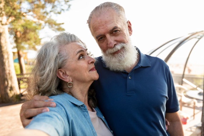 Elderly couple holding hands in park