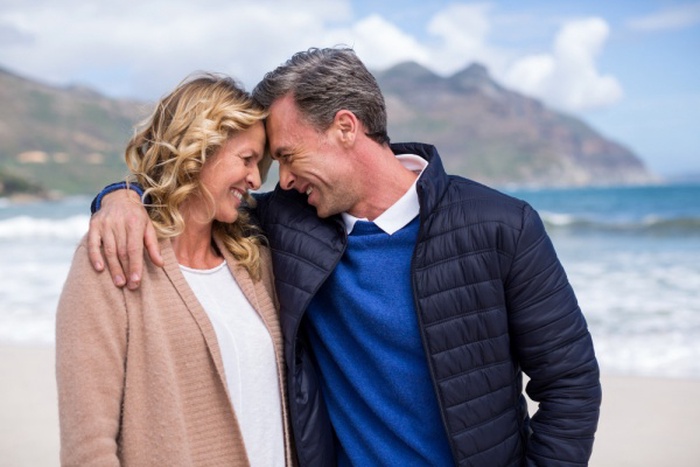 Mature couple standing face to face on the beach