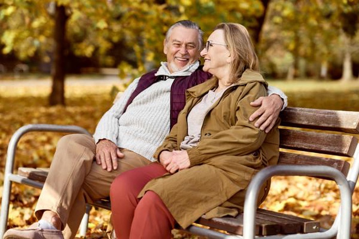Senior caucasian couple sitting at the bench in park