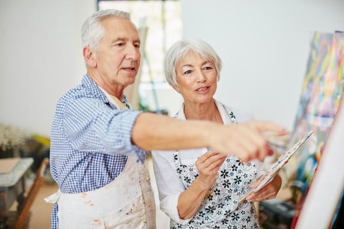 Senior couple painting together on an art date