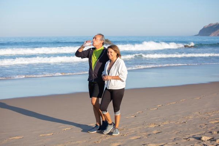 Active senior couple walking and exercising together on Flagler Beach Florida coastline