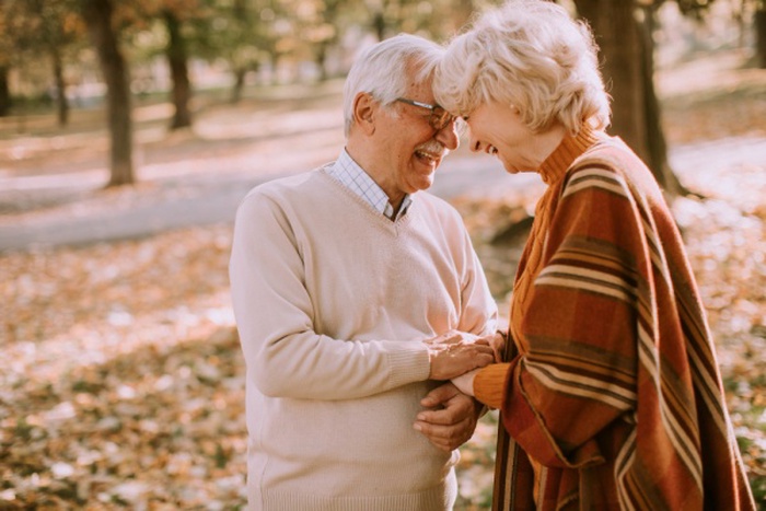 Handsome senior couple embracing in autumn park