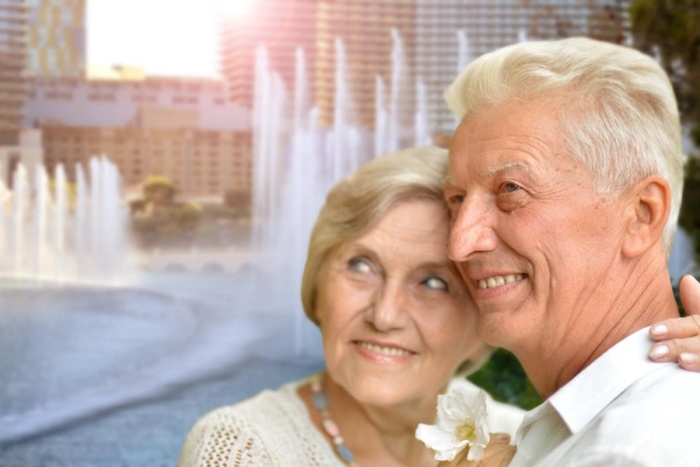 happy senior couple hugging against city skyline