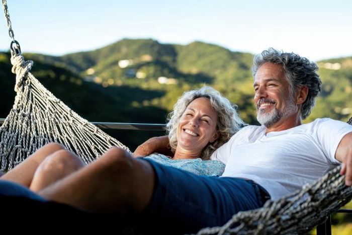Senior couple relaxing together in hammock smiling