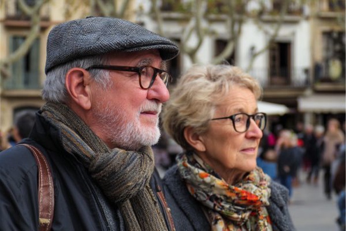 Pareja mayor paseando por la Plaza del Mercadal en Reus.