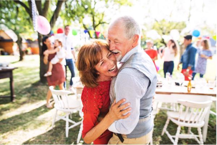 Loving senior couple hugging at outdoor garden party