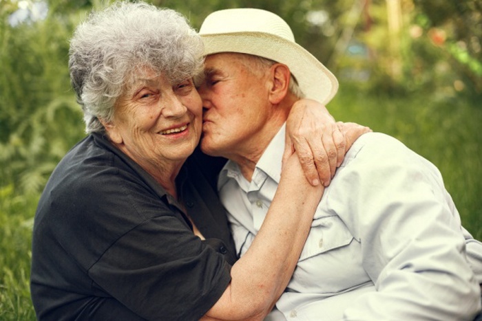 Beautiful old couple spend time in a summer garden