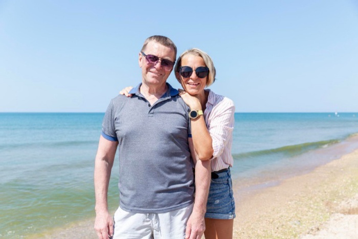 An adult daughter with an elderly dad at sea happy family smiling and hugging love and tenderness