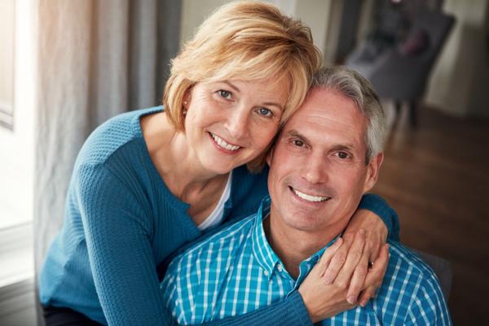 Happy middle-aged couple sharing a loving embrace indoors