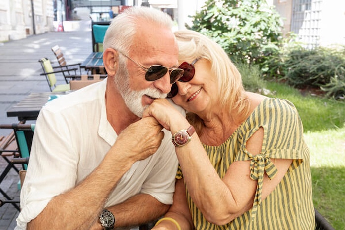 happy old man kissing ladys hand