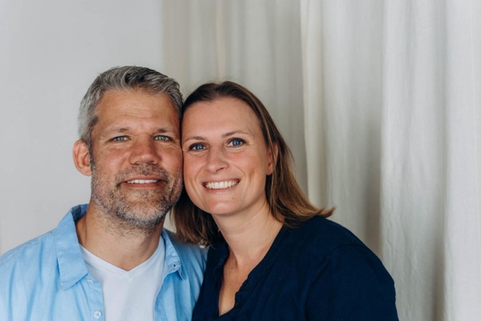 A happy couple is having fun at home while sitting onthe floor