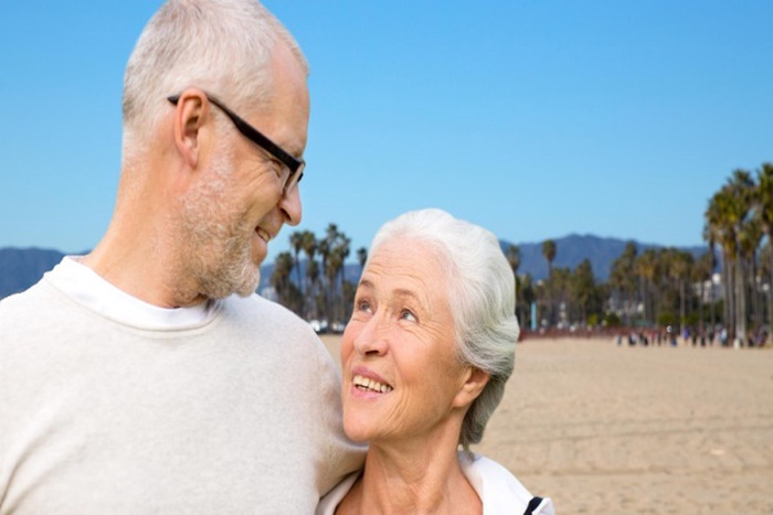 happy senior couple hugging over venice beach