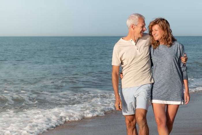 mature couple walking Worthing seafront promenade West Sussex England