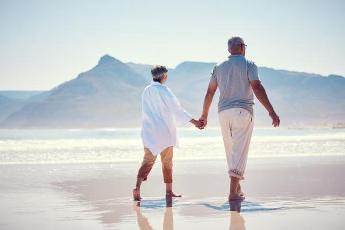 old couple walking on the beach